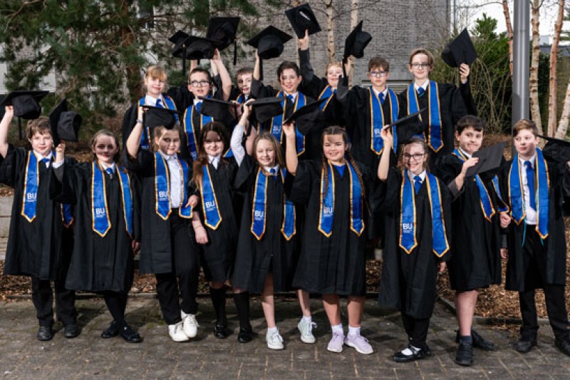 Visiting students dressed in their graduation outfits for the Books and Stories programme