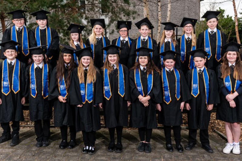 Visiting students dressed in their graduation outfits for the Books and Stories programme