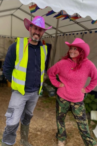 Meg and Jon in a Gazebo on a dig site wearing colourful hats