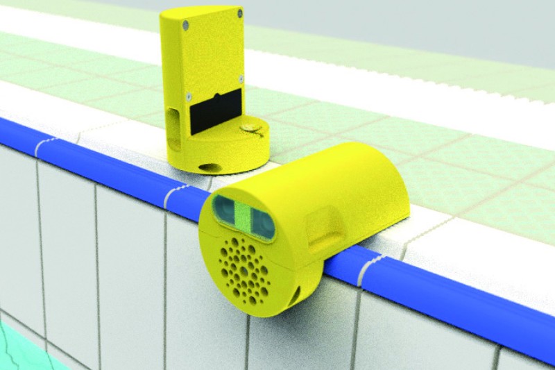 Swim Vision Two small yellow devices, one of which is attached to the side of a swimming pool, the other is sitting next to it.
