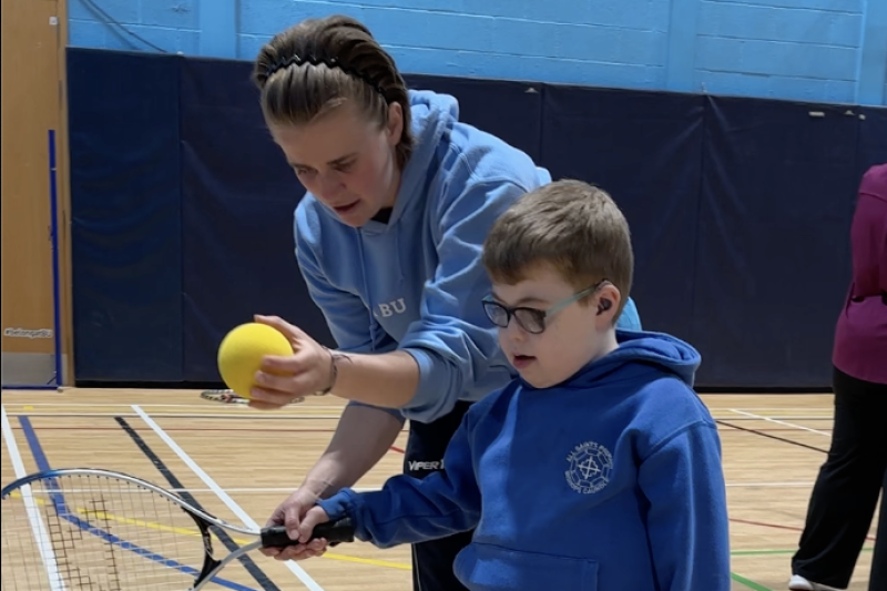 Tabby coaching a child during the racket session
