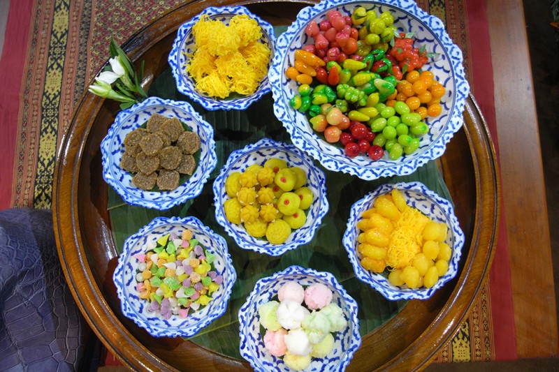 A selection of colourful Thai sweets in bowls on a table
