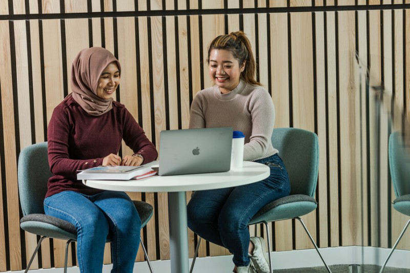 Two students looking at a laptop
