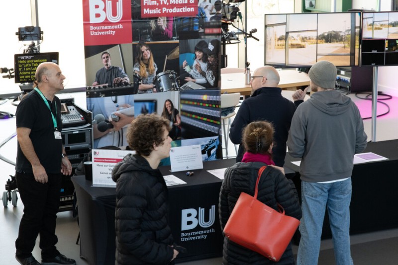 People talking to someone at a stall for TV Production