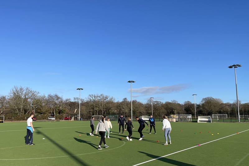A group of male and female students playing walking football on an artificial pitch