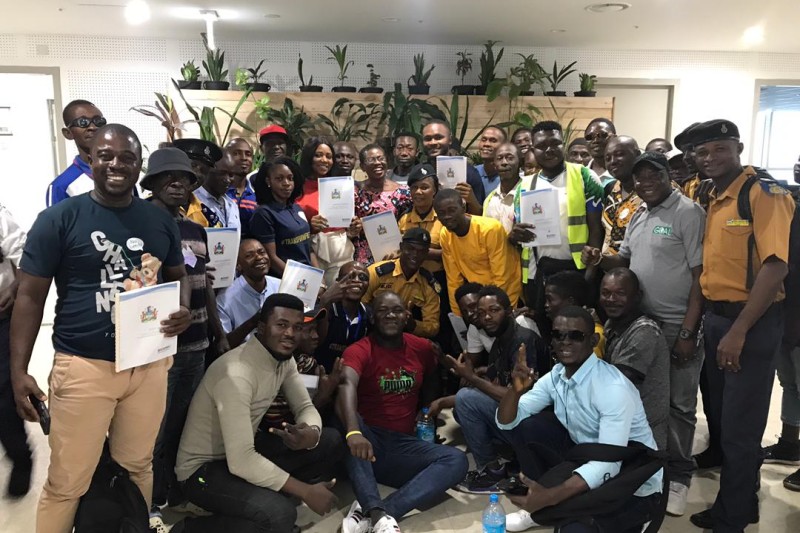 A group photo of staff from the local authorities and emergency services holding copies of the disaster management plans