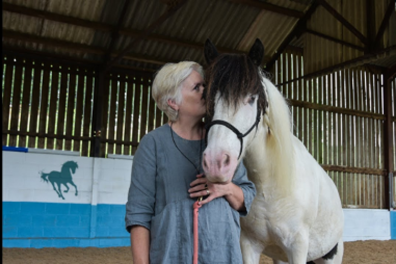 Professor Ann Hemingway next to a white horse