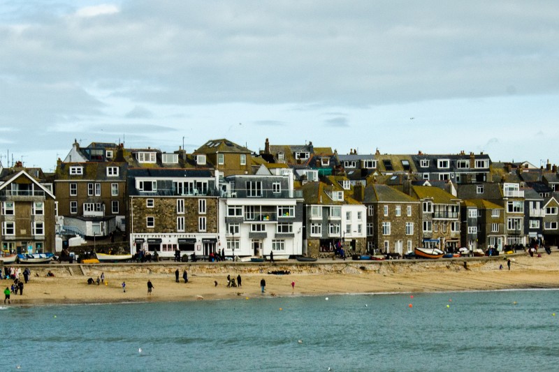 Coastal town Sea in the front, a sandy beach behind and some old looking buildings in the background