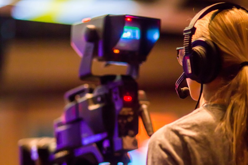 A woman operating a camera from behind