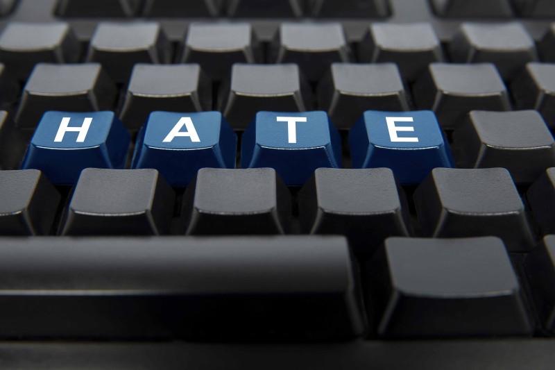 A computer keyboard with the word HATE written across four keys