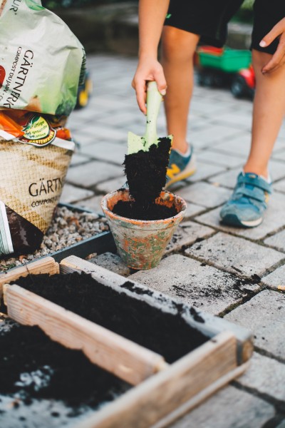 A person using a trowel to move compost