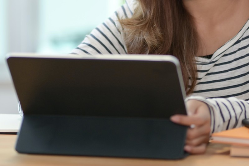 Student using tablet at desk Student using tablet at desk