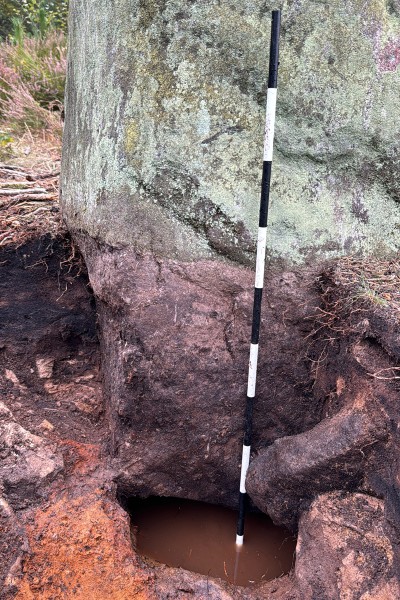 The bottom of the Farley Stone. The ground at the base of the stone has been excavated to reveal a spring