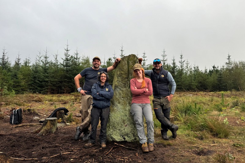 two men and two women leaning against the Farley Stone which is two metres tall.