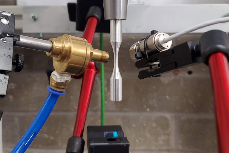 A close up image of the ultrasonic fatigue testing of a metal element