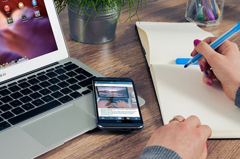 writing at desk with laptop